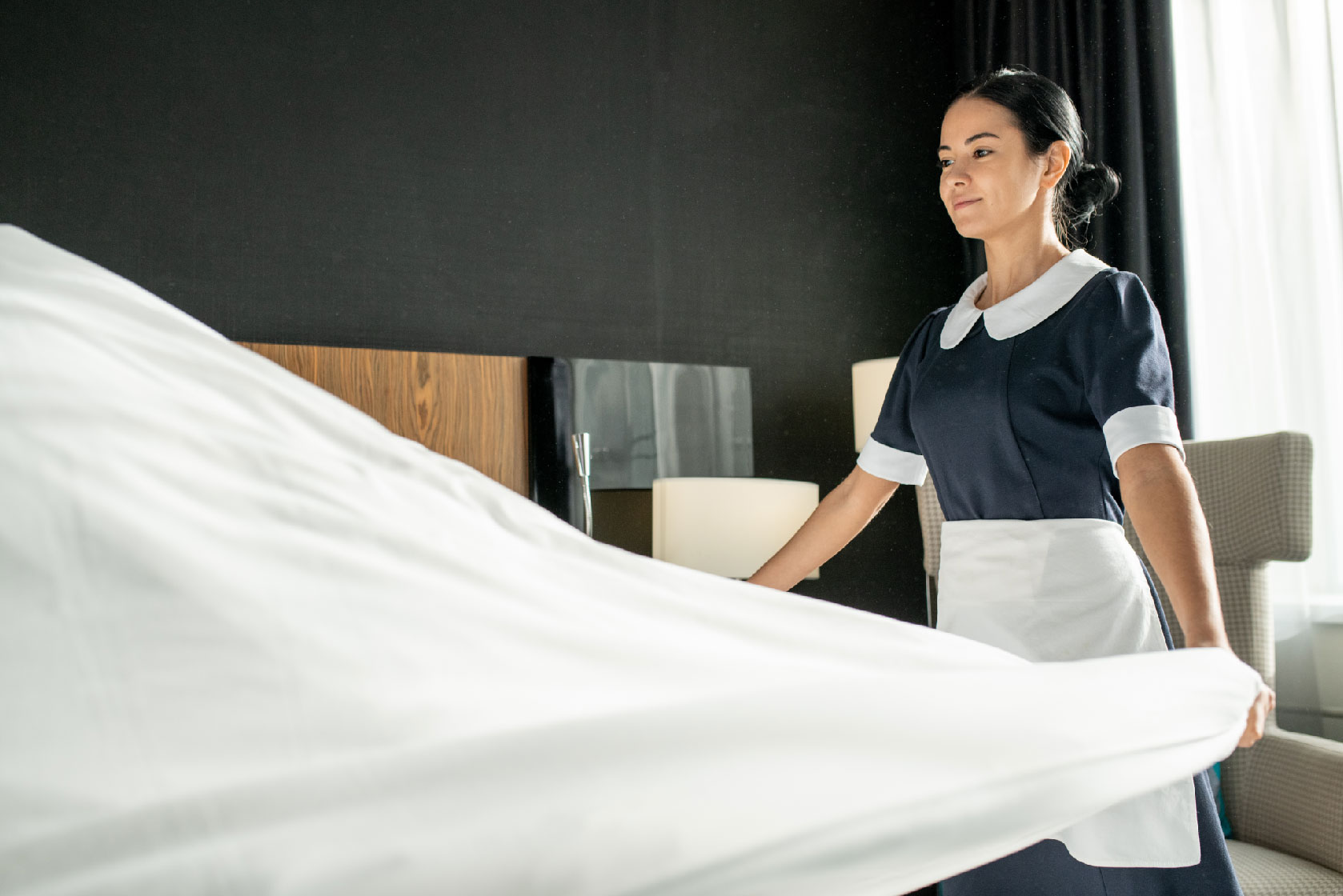 Housekeeper making the bed